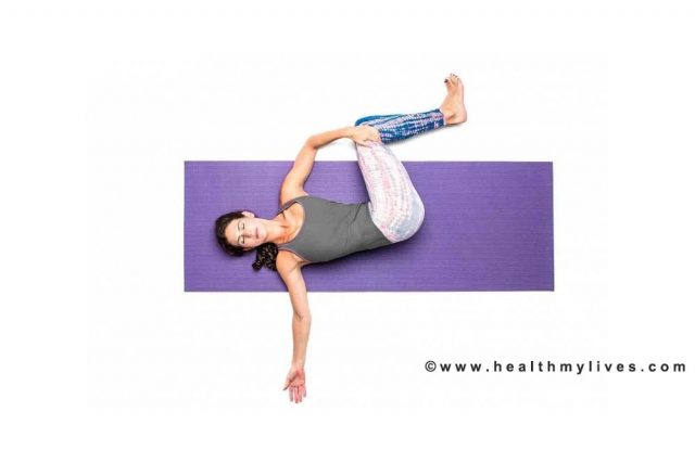 Acostado en la postura de la columna vertebral de yoga para el dolor de espalda