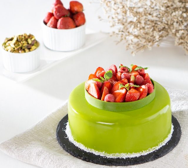 green cake topped with fruits